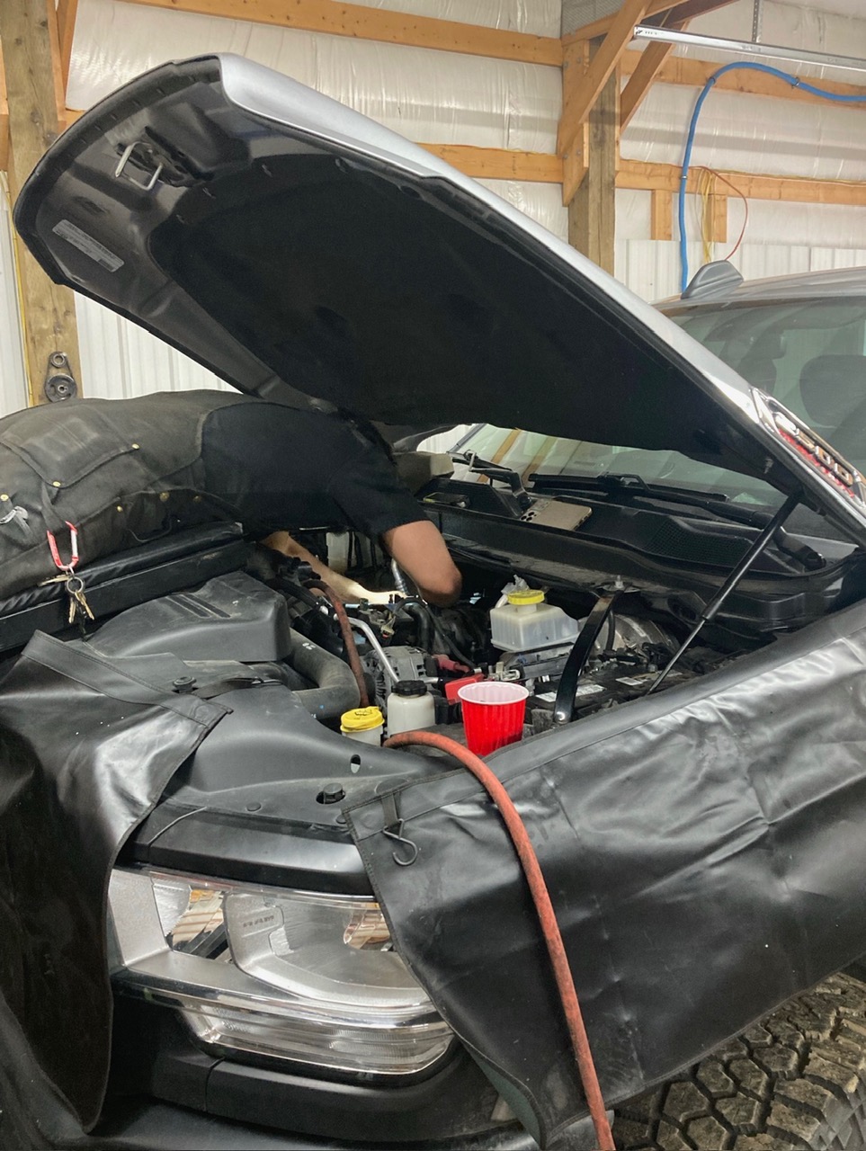 Technician working under the hood of a Ram truck
