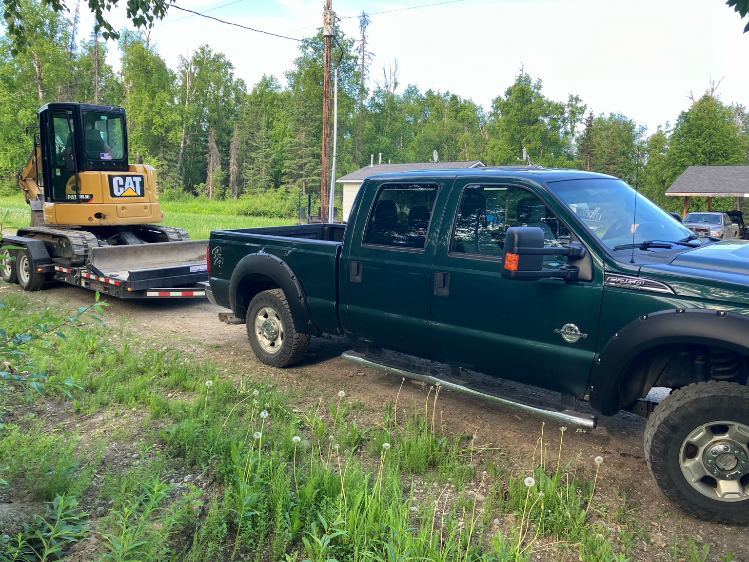 Truck towing a trailer with compact excavator